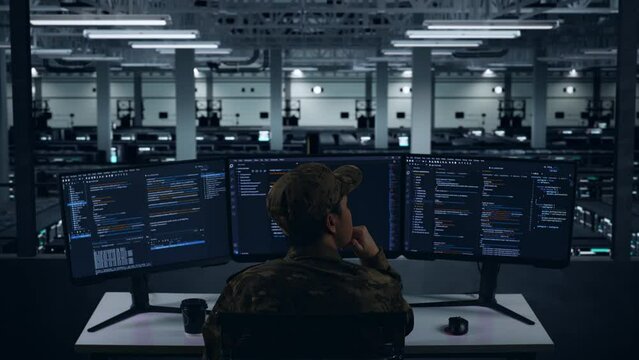 Back View Of Asian Military Thinking About Something While Write Code With Multiple Computer Screens In Data Center
