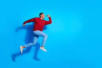 Fototapeta na wymiar Full body profile photo of cheerful energetic person jump run empty space isolated on blue color background