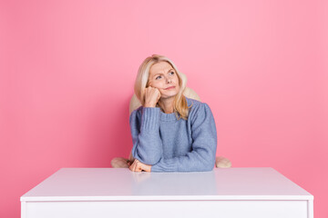 Photo of upset unsure woman wear pullover sitting office looking empty space isolated pink color background - obrazy, fototapety, plakaty