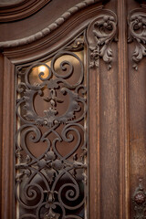 forged decorative elements on wooden doors.  beautiful retro doors. metal decoration on the door. wooden carved doors
