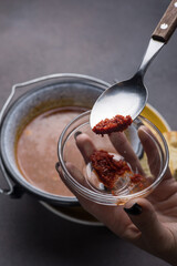 Soup with meat and vegetables in a pot on a dark background