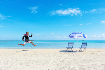 Happy businessman running from the work on the tropical beach. Summer vacation concept.