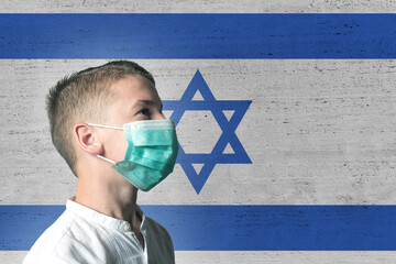 Boy in a medical mask on his face on background of Izrael flag. Epidemic virus 2019-nCoV Respiratory Syndrome. Medicine concept.