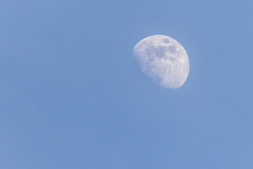 Aufnahme des dreiviertel Mondes am Himmel bei Tag.