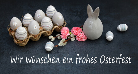 Grußkarte Frohe Ostern: Graue Ostereier und ein Dekohase mit dem Ostergruß wir wünschen ein...