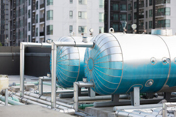 Water pipes system and hot water boiler system tank at rooftop of building. Hot water buffer tank network system on the building rooftop - obrazy, fototapety, plakaty