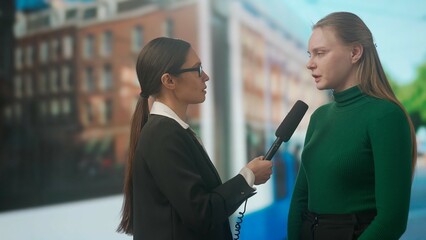 Female presenter reporting on air outside. Woman news host journalist taking interview with young...