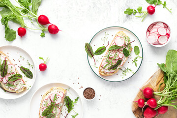 Radish sandwiches with cottage cheese and fresh green leaves, top down view