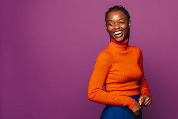 Happy smiling woman with vibrant two-tone braids in colorful studio
