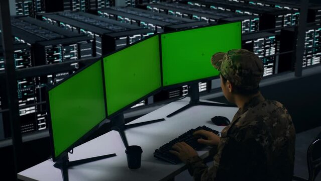 Side View Of Asian Military Drinking Coffee And Working With Mock Up Multiple Computer Monitor In Data Center
