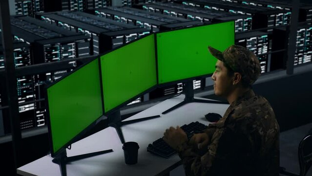 Side View Of Asian Military Thinking About Something Then Raising his Index Finger While Working With Mock Up Multiple Computer Monitor In Data Center