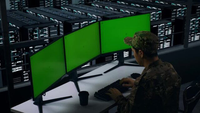 Side View Of Tired Asian Military Stretching While Working With Mock Up Multiple Computer Monitor In Data Center