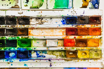 Background, texture of watercolor paints in disarray, in a dirty box.