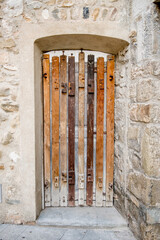 An old wooden door in a stone house. Designer handmade door. Retro wooden door in the old town.