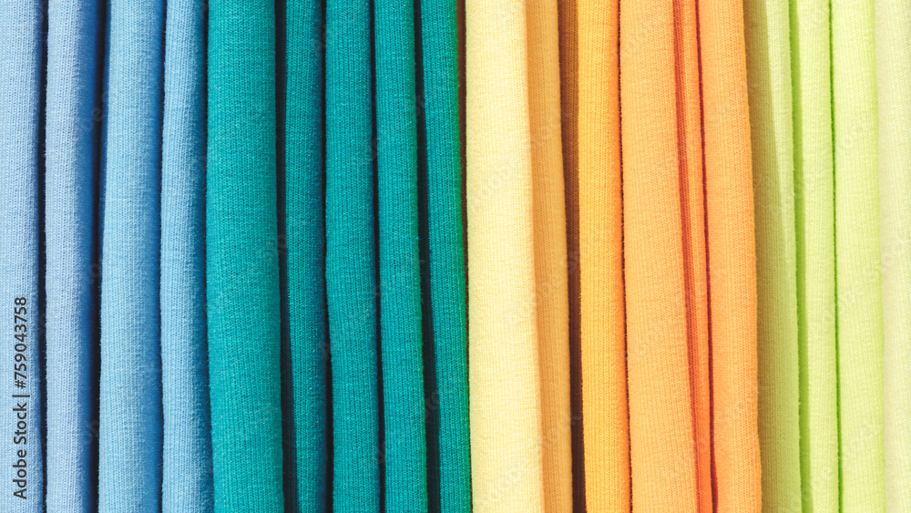 Poster multi-colored textile fabrics hang in a market or store as an abstract background