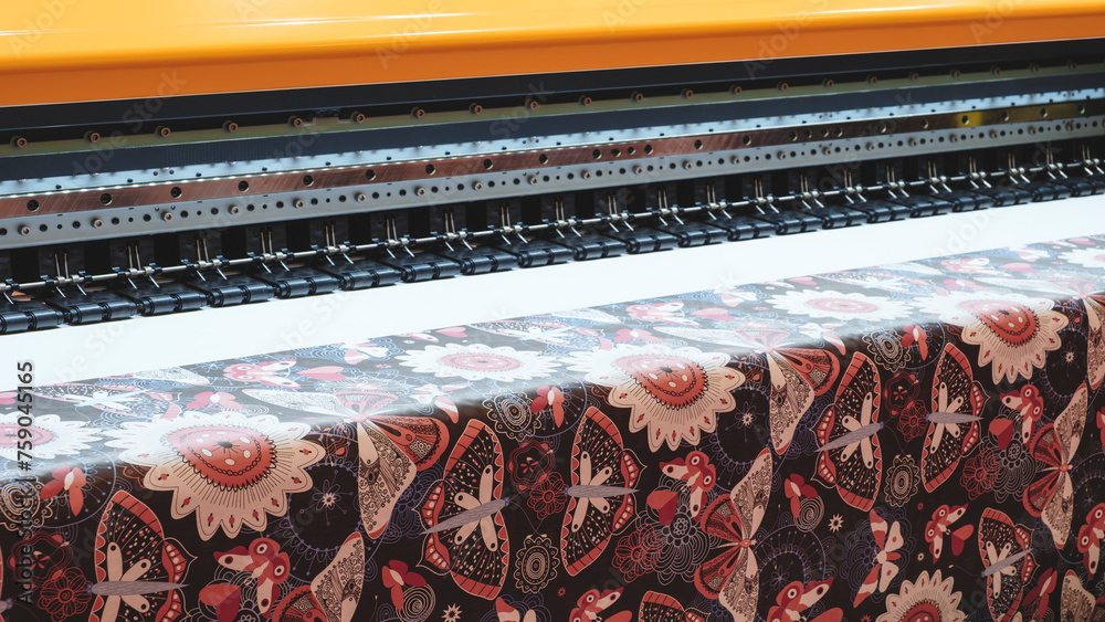 Poster a machine is printing a pattern on a piece of fabric. the pattern is floral and has a mix of colors.