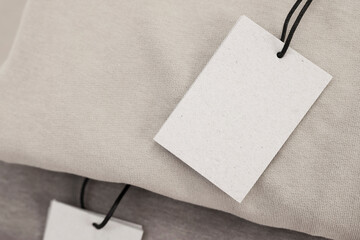 Naklejka premium Cardboard tags on garment, closeup. Space for text