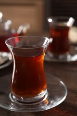 Traditional Turkish tea in glass on wooden table, closeup