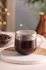 Delicious coffee in cup on white wooden table
