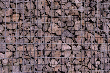 gabion wall with grey stones in a metal grid
