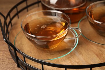 Aromatic tea in glass cups on wooden table, closeup