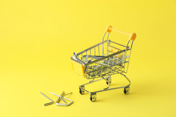 Small shopping cart with hexagon wrench set on yellow background. Construction tools