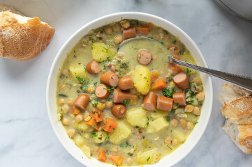 Potato soup with chick peas and sausage on a plate