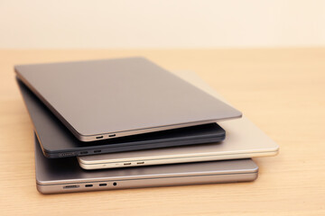 Different modern laptops on wooden table, closeup