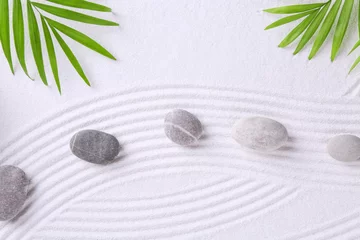 Rolgordijnen Zen garden stones and green leaves on white sand with pattern, flat lay © New Africa