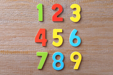 Colorful numbers on wooden table, flat lay