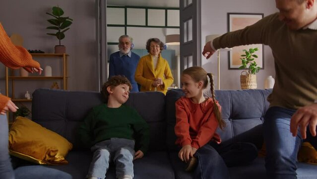 Smiling girl looking at brother while sitting on couch