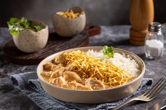 Chicken stroganoff with rice and straw potatoes. Strogonoff.