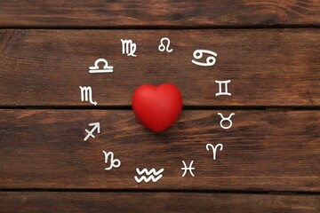 Zodiac signs and red heart on wooden background, flat lay