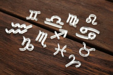 Many transparent zodiac signs on wooden table