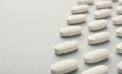 Vitamin pills on light grey background, closeup with pace for text. Health supplement