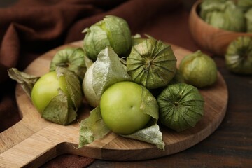 Fresh green tomatillos with husk on wooden table, closeup