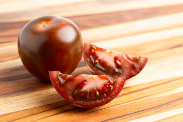 A Sweet Juciy Brown Kumato Tomato on a Wooden Cutting Board