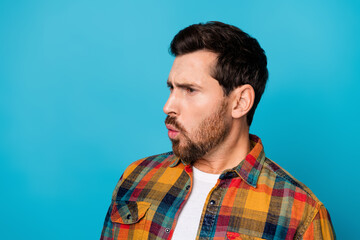 Portrait of astonished guy with stubble wear checkered shirt look at profitable proposition empty space isolated on blue color background