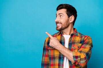 Photo of funky impressed man with beard dressed plaid shirt directing staring at promo in empty...
