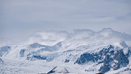 Arctic of ice mountain ranges at snow landscape. Nobody wild nature environment scenery of climate change. Cold winter at white snowy cloudy day with iceberg glacier mount at Antarctica
