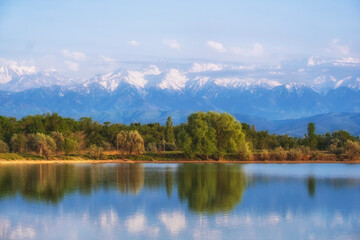 Fototapeta na wymiar Lake near high snowy mountains in summer with a beautiful reflection