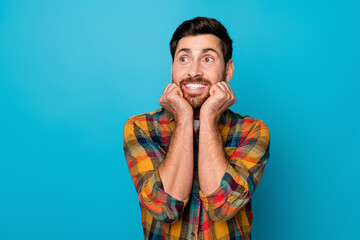 Portrait of funny dreamy guy with stubble wear checkered shirt look empty space arms on cheekbones...