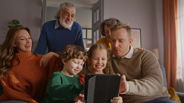 Grandparents looking at tablet in hands of smiling girl