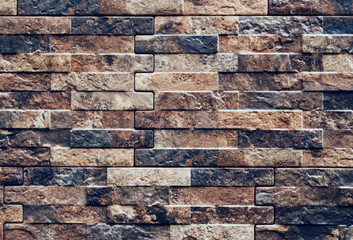 Decorative tiles under the brick on the facade of the house. Abstract brown brick wall background	