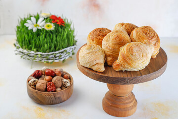 Traditional Azerbaijan holiday Novruz background with green semeni,traditional azerbaijan sweets,shekerbura,qogal,paxlava,mutaki and different nuts and sweets,top view,space for copy