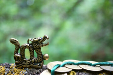 A metal dragon figurine and Chinese coins. Amulets and talismans.