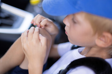 Little boy scratching his knee. Boy with scab on his knee. Closeup.