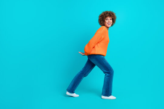 Full length profile side photo of cheerful motivated persistent woman carry empty space isolated on blue color background