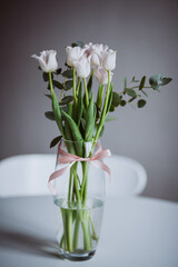 Pink tulips are in a vase in the room.