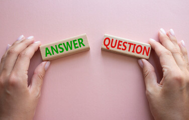 Answer or Question symbol. Concept word Answer or Question on wooden blocks. Businessman hand....